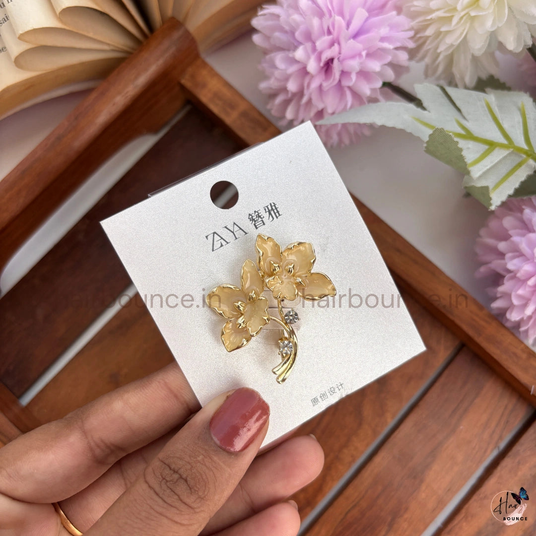 Elegant Gold Floral Brooch with Crystal Accent